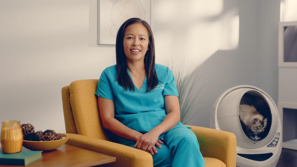 Dr Justine Lee sitting near Litter-Robot