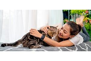 woman petting tabby cat