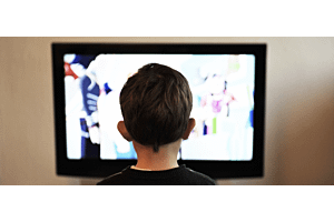 back of boy's head as he watches cartoon TV
