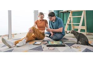 two people playing board game with cat watching