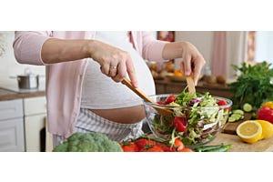 pregnant person making salad