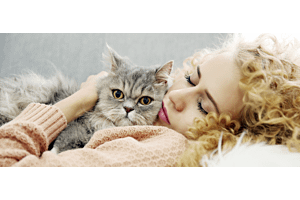person cat cuddled by woman