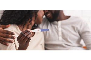 happy man and woman holding positive pregnancy test