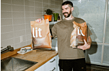 LRC man holding two Lit premium cat litter bags Thumbnail