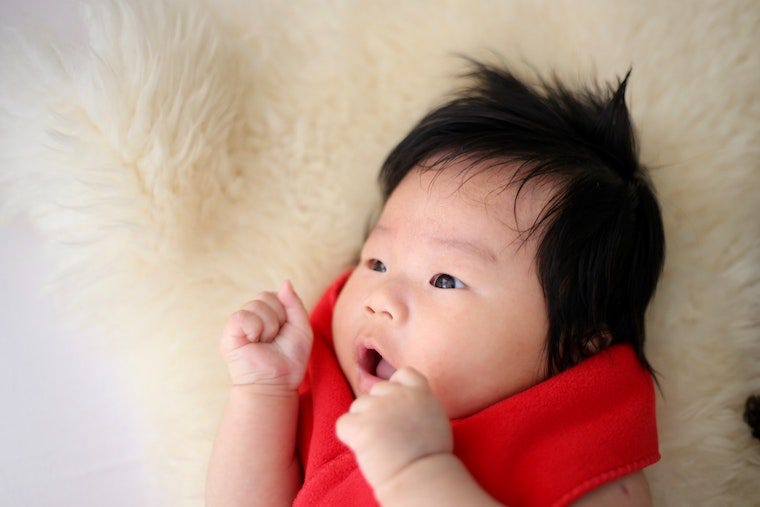 baby with black hair on soft blanket - what is cute aggression
