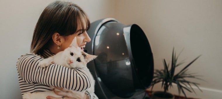 Woman hugging a cat next to Litter-Robot 3