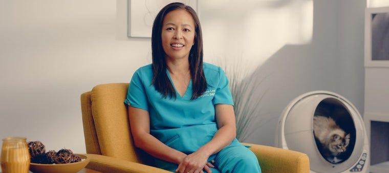 Dr Justine Lee sitting near a Litter-Robot with cat