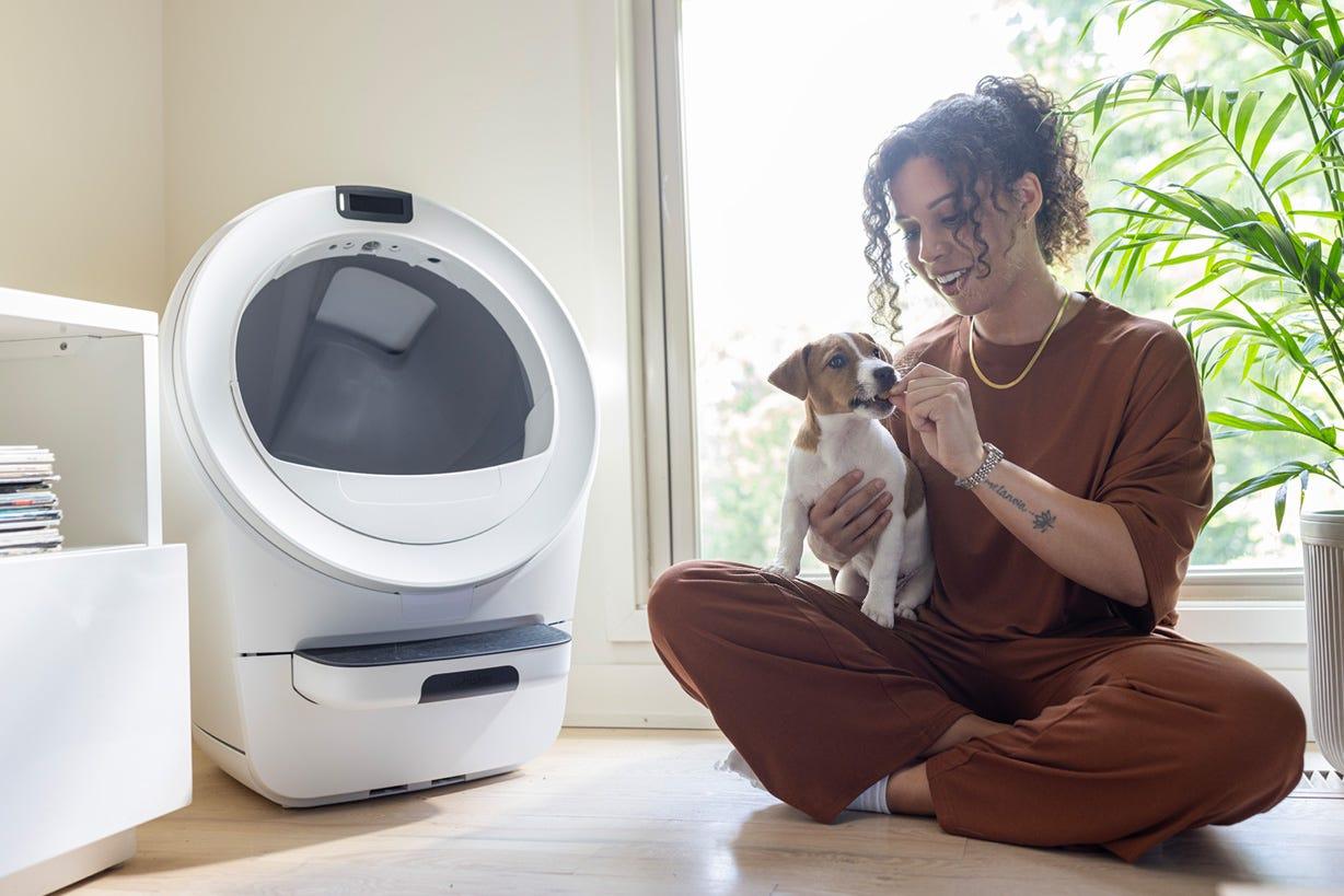 woman giving treat to a dog after positive interaction with Litter-Robot