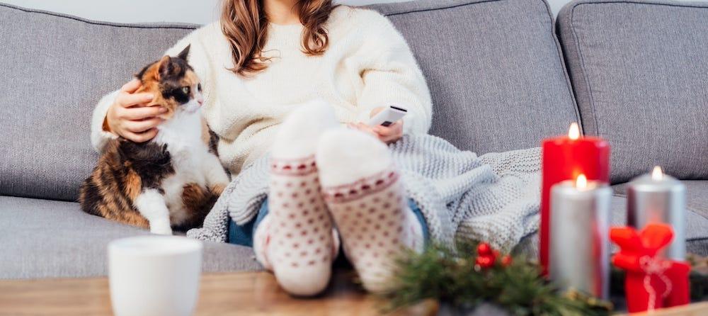 woman watching Christmas movies with cat