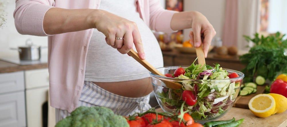 pregnant person making salad