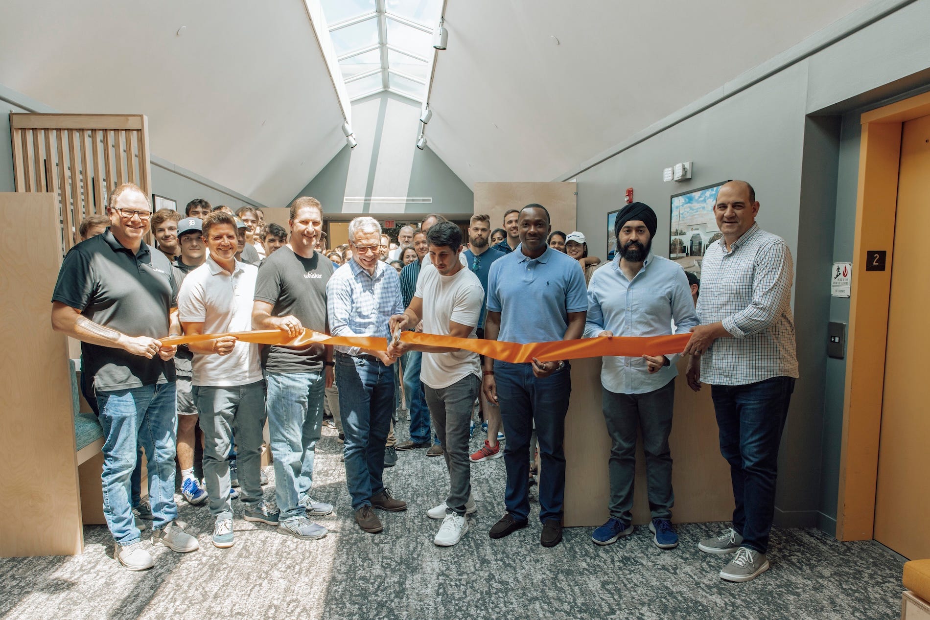 Jacob Zuppke cutting ribbon with Brad Baxter and team in Whisker headquarters