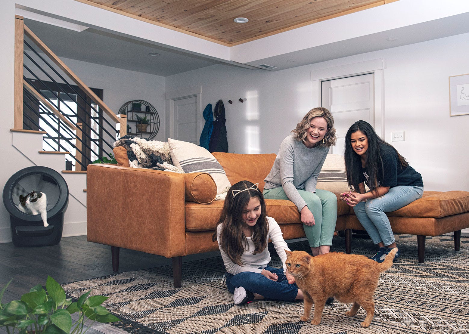 Women and child playing with cat in front of Litter-Robot 4