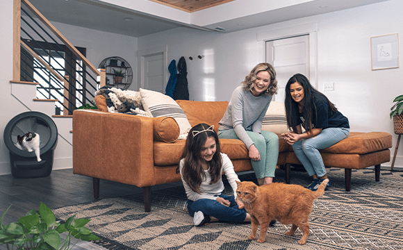 Women and child playing with cat in front of Litter-Robot 4