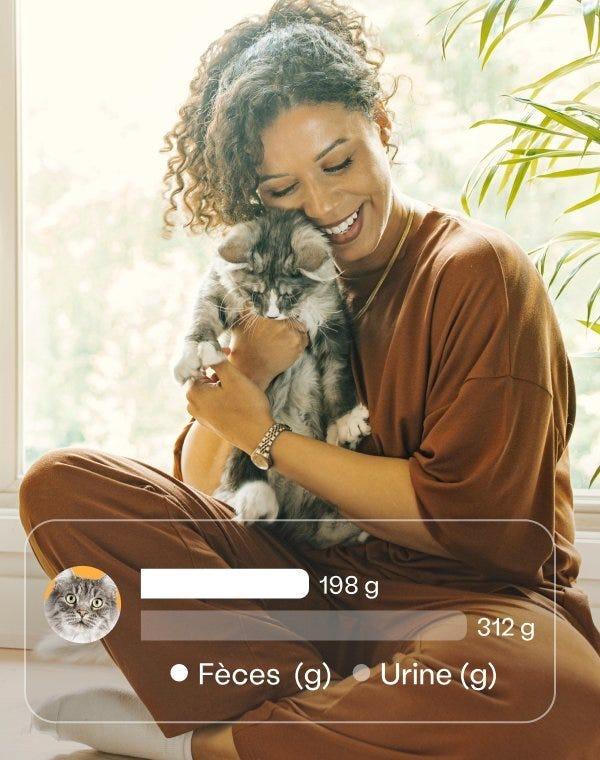 Smiling woman cuddling a fluffy gray cat, with an app overlay displaying waste tracking data: 198g feces and 312g urine