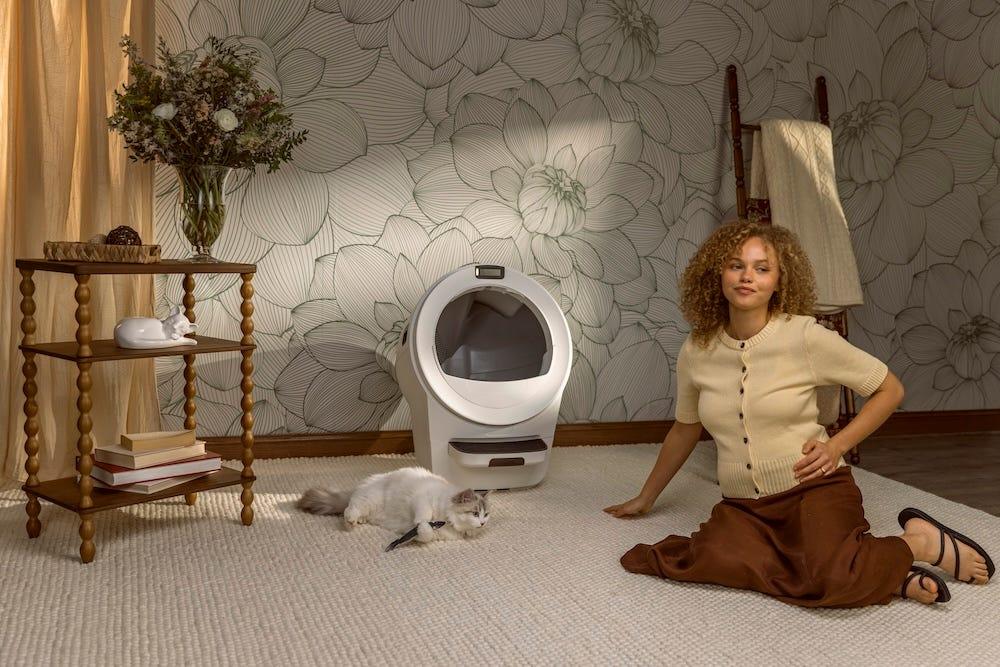 pregnant woman sitting near Ragdoll cat and self-cleaning litter box Litter-Robot 5