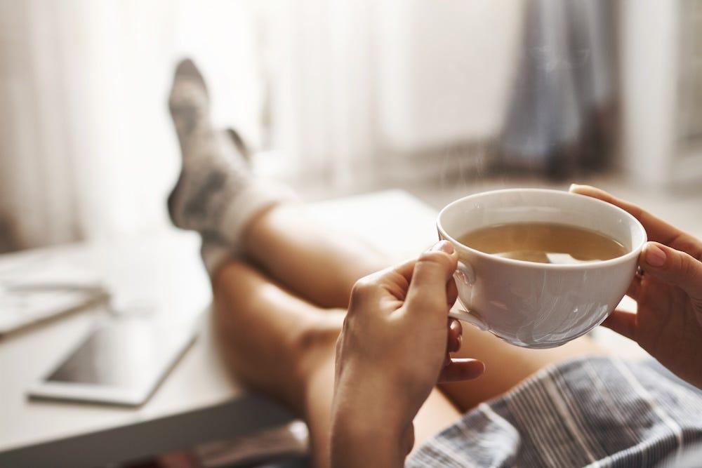 woman holding cup of tea